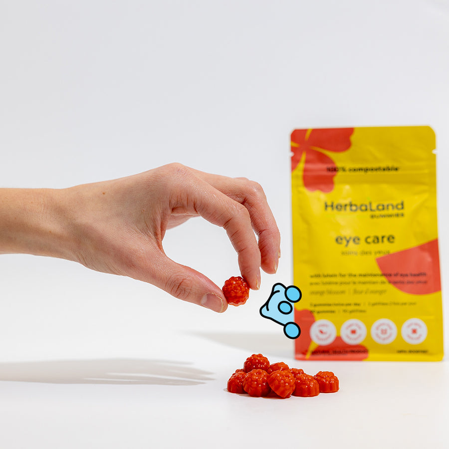 Person holding herbaland gummies, with eye care pouch for maintenance of eye health for adults with orange blossom flavor