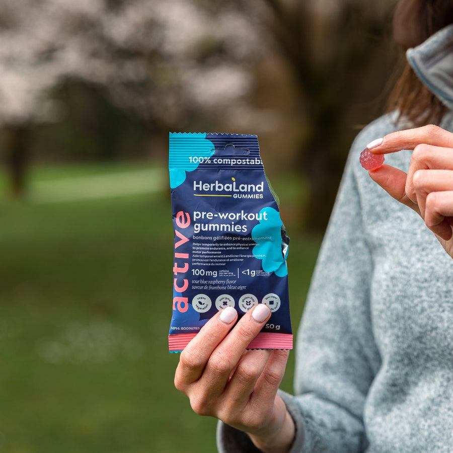 A picture of a person holding pre-workout gummies to boost motor performance for adults with sour raspberry flavor